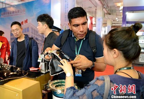 2018年4月19日，第二十届中国(晋江)国际鞋业暨第三届国际体育产业博览会在福建省晋江市开幕，引来了70个国家和地区的企业、采购商和专业买家。 图为国外客商&ldquo;鞋博会&rdquo;上&ldquo;淘宝&rdquo;。<a target='_blank' href='http://www.chinanews.com/'>中新社</a>记者 王东明 摄