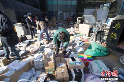 资料图：双十一期间物流工作人员正在分拣快递。 张云 摄