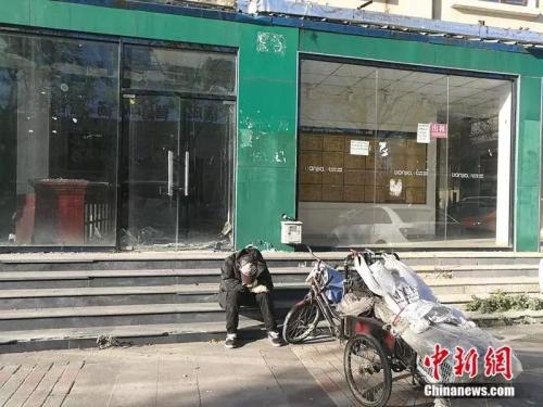 2018年10月，燕郊&ldquo;售楼一条街&rdquo;，已经关门的链家门店前停着一辆装货的三轮车，车的主人坐在地上，把头深深地埋进臂弯。<a target=\'_blank\' href=\'http://www.chinanews.com/\' >中新网</a>记者 邱宇 摄