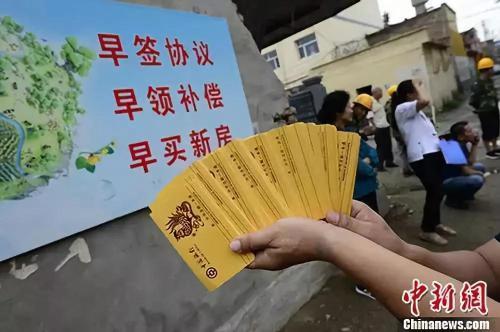 资料图：福州民众从万科楼盘工地旁经过。<a target=\'_blank\' href=\'http://www.chinanews.com/\'>中新社</a>记者 张斌 摄